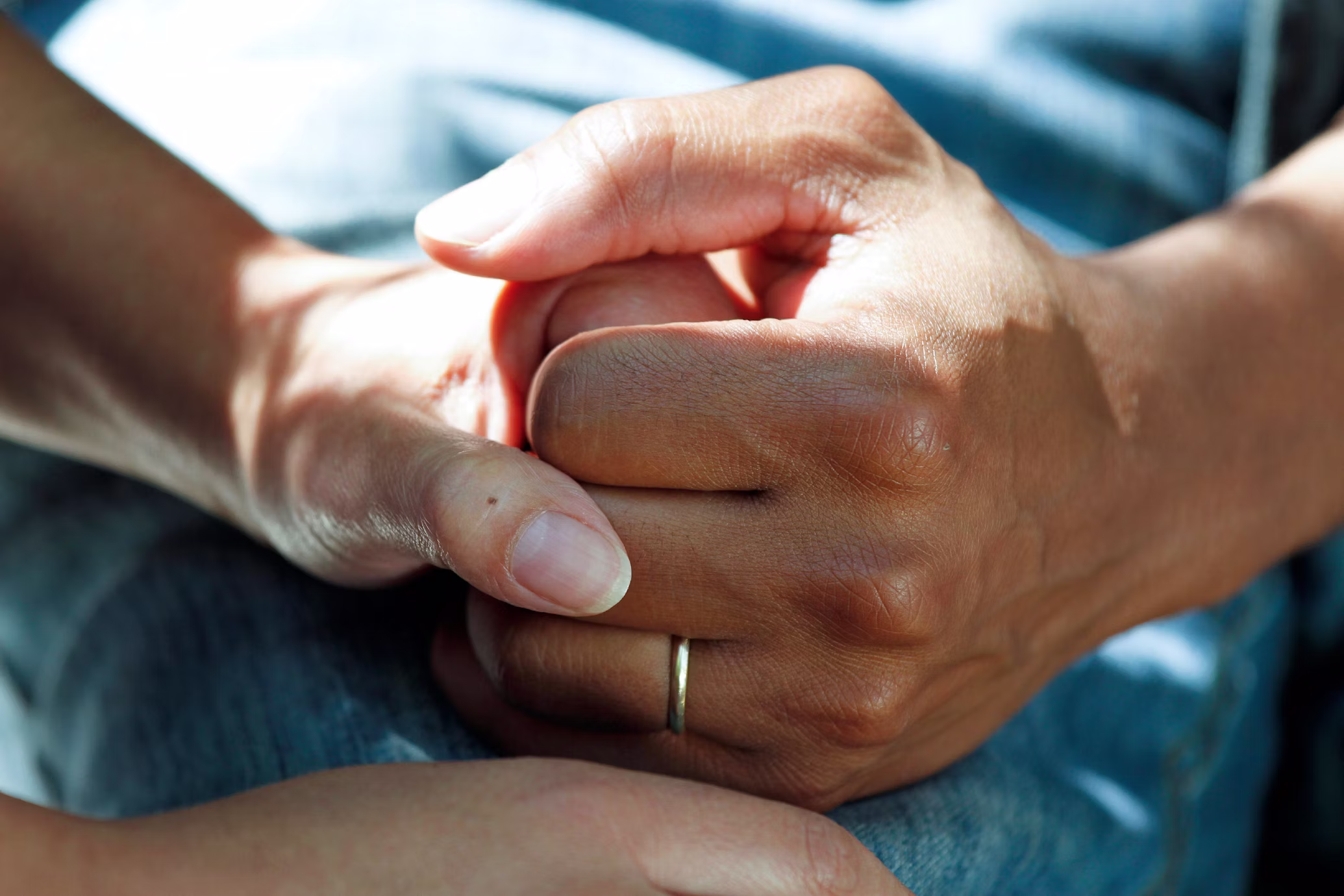 Two people holding hands, offering reassurance and support